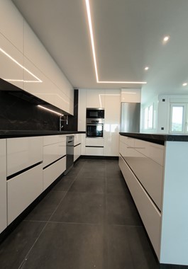 COCINA MODERNA CON ISLA EN FORMICA BLANCA CON PERFIL GOLA Y PORCELÁNICO EN NEGRO